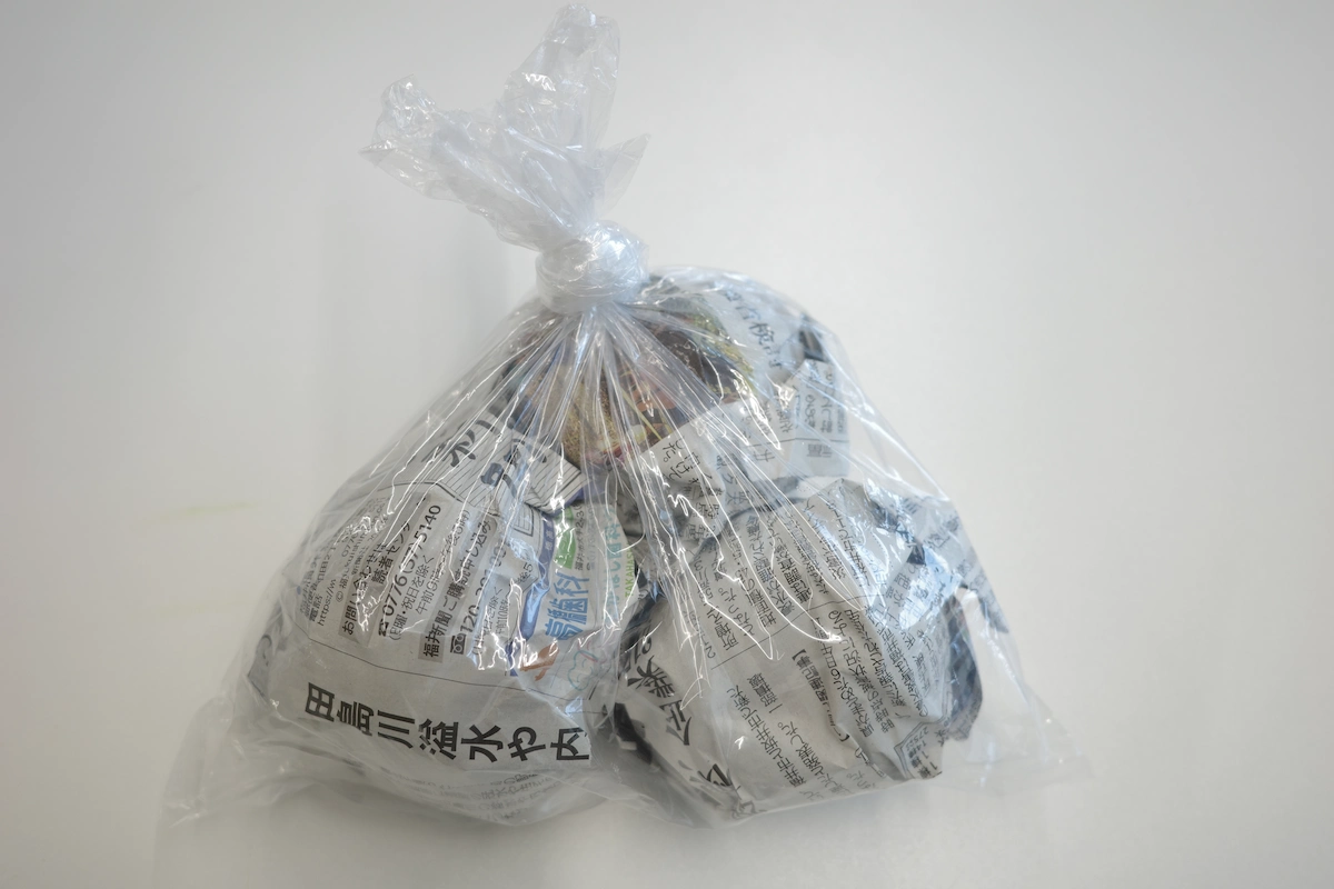 りんごを１玉ずつ新聞紙で包み、ポリ袋に入れて口を縛った冷蔵保存の準備